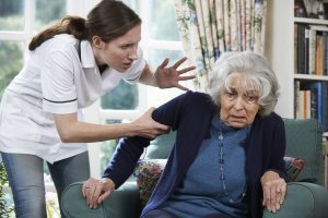 Photo of a care worker mistreating a senior woman
